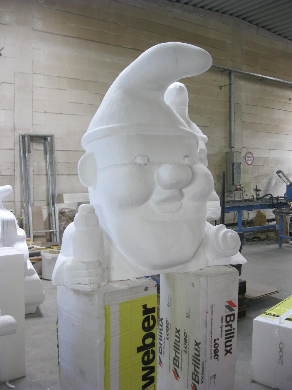 Weiße, noch unbemalte Gartenzwerg-Figur mit Hut und Gesicht in der Werkstatt