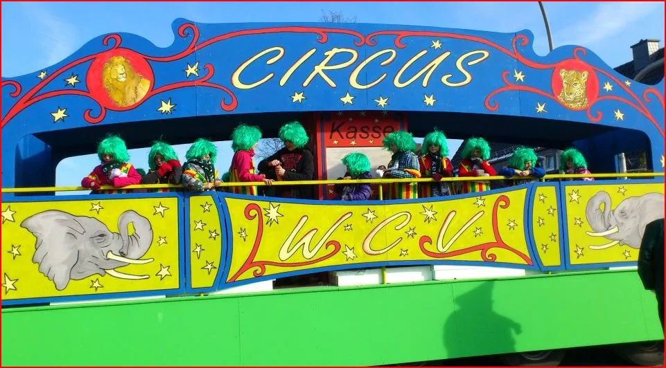 Bunter Circus-Wagen mit blauem Bogen und gemalten Tiermotiven im Umzug